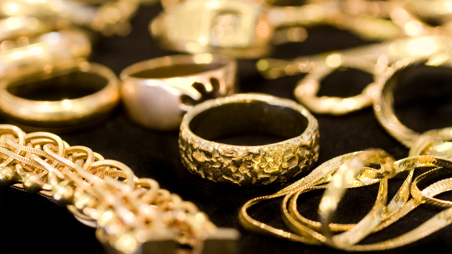 Close-up of vintage gold rings, chains, and bracelets.