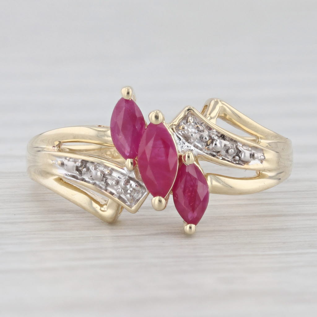 Light Gray 0.70ctw Lab Created Ruby 3-Stone Bypass Ring 10k Gold Size 7.25 Diamond Accents