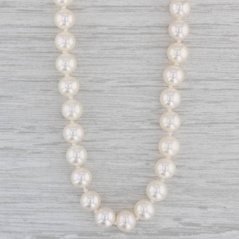 Premium Photo | White pearl necklace on white tray and blue silk background