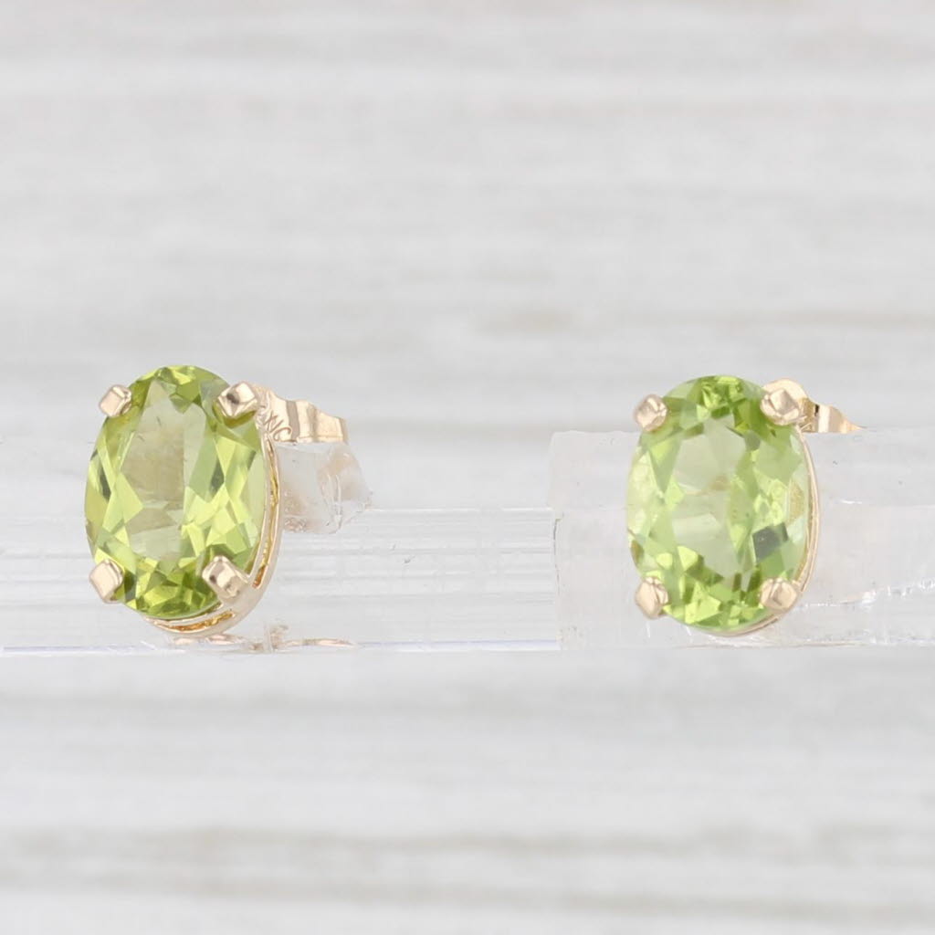 Light Gray 1.54ctw Oval Peridot Solitaire Stud Earrings 14k Yellow Gold