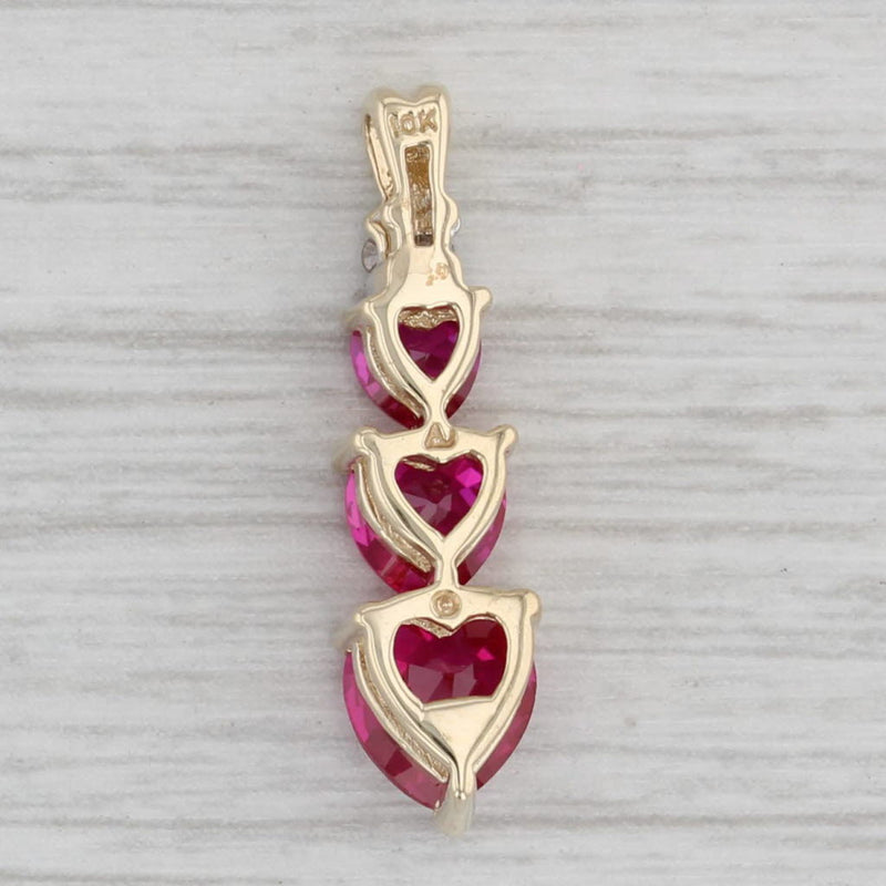 Gray 1.80ctw Lab Created Ruby Hearts Pendant 10k Gold Diamond Accent 3-Stone Journey
