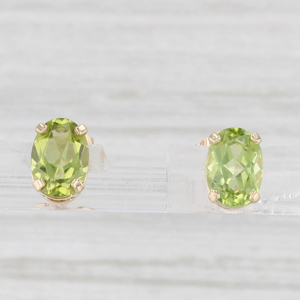 Light Gray 1.54ctw Oval Peridot Solitaire Stud Earrings 14k Yellow Gold